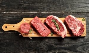 Steaks on wooden platter